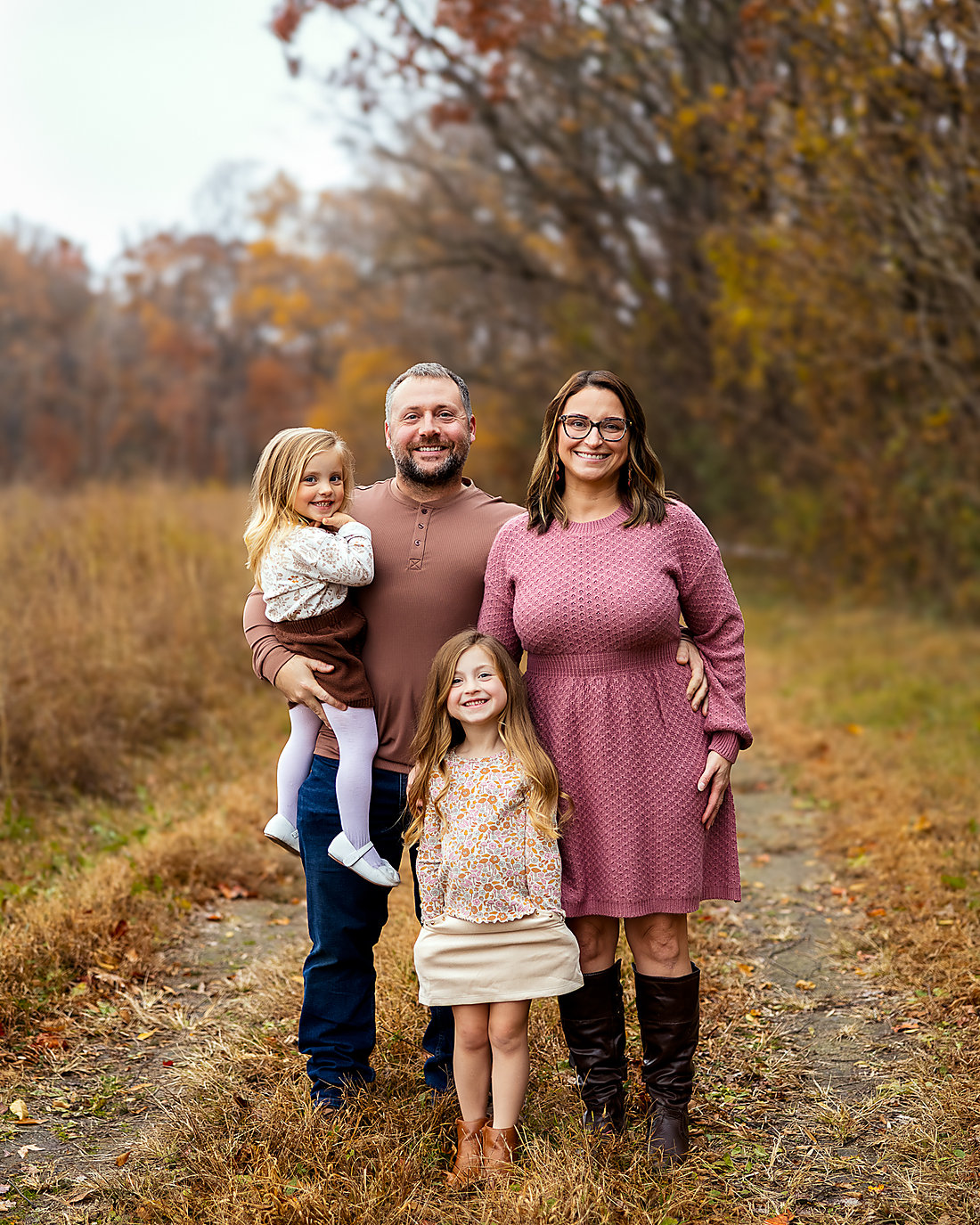 Justus with his wife and their two daughters in an autumn field