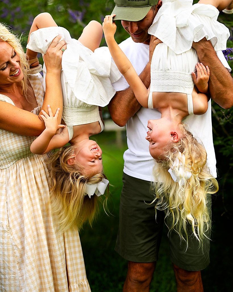 Mom and dad swinging their girls upside down