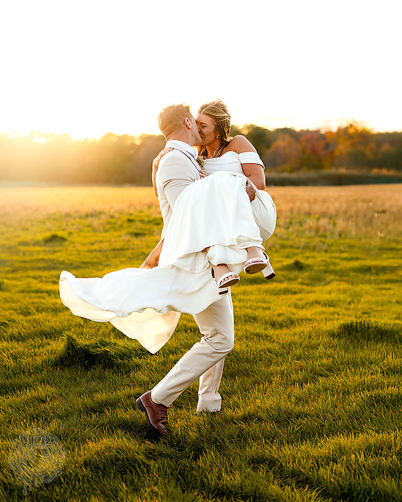 Him carrying her across a field at golden hour