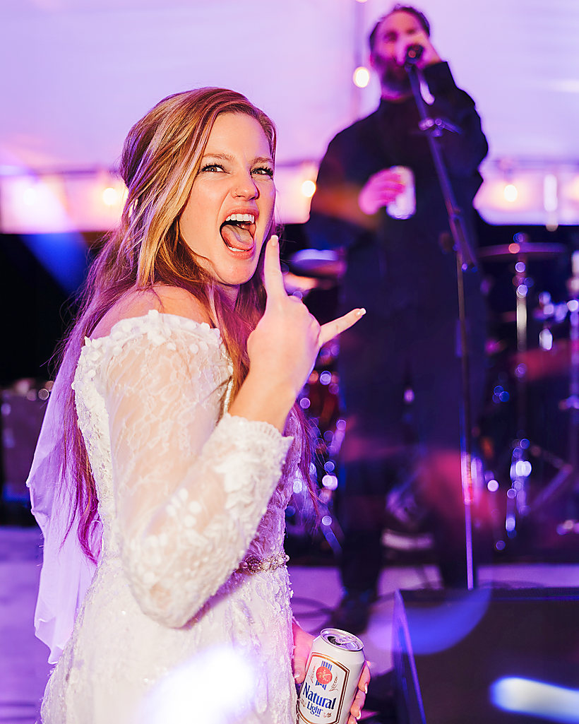 A bride celebrating in front of the band at her reception